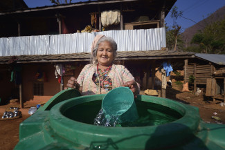 Eine Frau schöpft Wasser