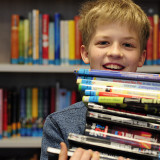 Kind leiht in der Bücherei Bücher aus